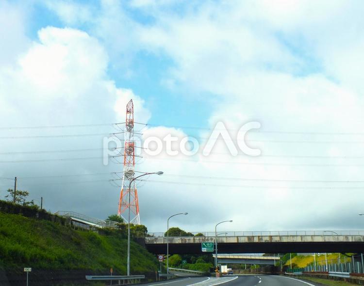 高くそびえる赤と白の送電塔と東名高速道路 出口,インター,送電塔の写真素材