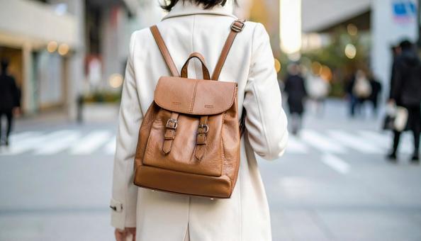 街中を歩いていくリュック姿の女性の後ろ姿 街中を歩いていくリュック姿の女性の後ろ姿の写真