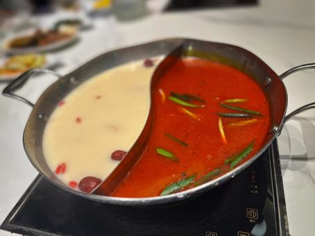 白湯と麻辣スープが並ぶ本格火鍋料理 白湯と麻辣スープが並ぶ本格火鍋料理 火鍋,鍋料理,白湯スープの写真素材