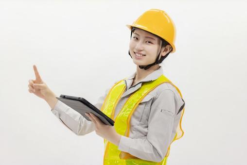 タブレットを使う作業服の女性 タブレットを使う作業服の女性 女性,作業員,ヘルメットの写真素材