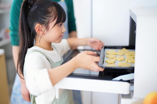キッチンでクッキーを焼く作業をする女の子 女の子,日本人,クッキーの写真素材