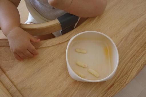 ハイローチェアでおやつを食べる赤ちゃん ハイローチェア,おやつ,赤ちゃんの写真素材