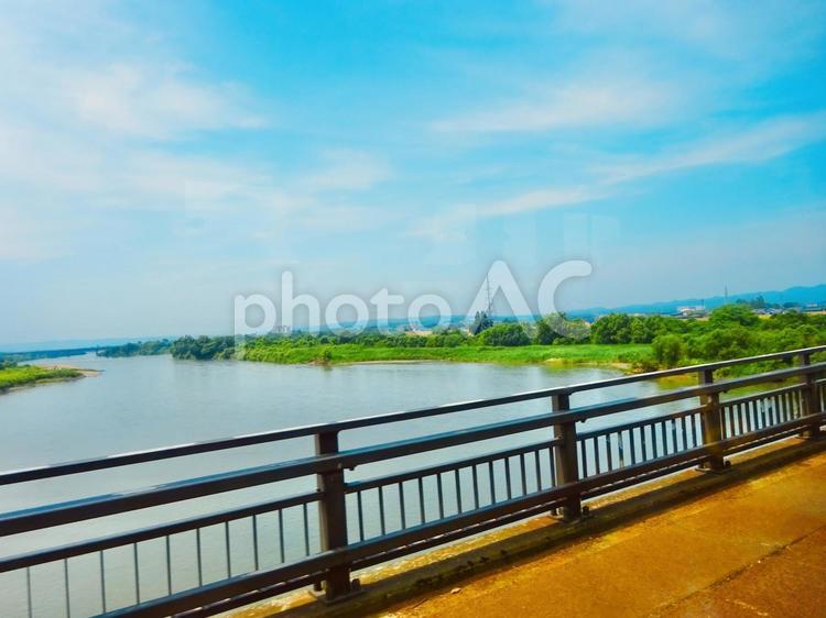 のどかな信濃川と橋の車窓 青空,空,絶景の写真素材