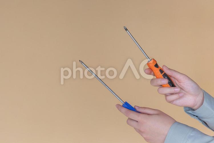 両手にドライバーを持っている手 ドライバー,工具,持つの写真素材