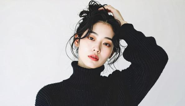 黒タートルの女性が髪をかき上げるポーズ 黒タートルの女性が髪をかき上げるポーズの写真