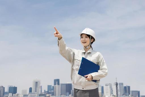 Woman in work clothes pointing, JPG