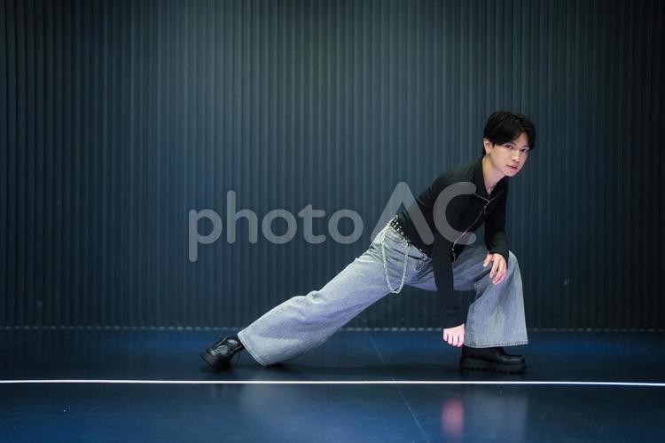 右足を伸ばしポーズするカメラ目線の男性 男性,アイドル,ポーズの写真素材