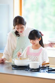 鍋の中のカレーを混ぜる女の子 鍋の中のカレーを混ぜる女の子 母,娘,女の子の写真素材
