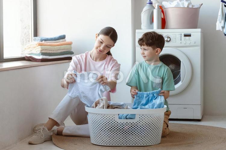座って洗濯物を仕分けする親子 親子,女性,男の子の写真素材