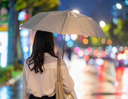 雨の日に傘をさして帰る女性会社員 雨の日に傘をさして帰る女性会社員の写真