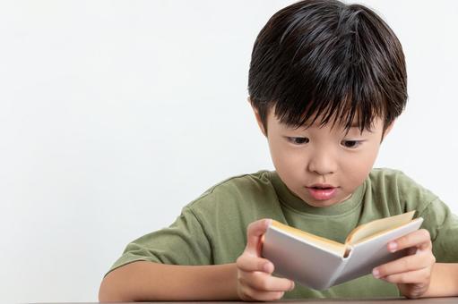 夢中で本を読む男の子 夢中で本を読む男の子の写真