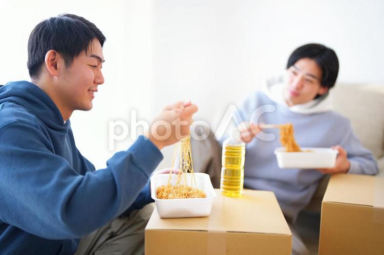 引っ越しの合間にカップ焼きそばを食べる2人の男性 引っ越し,一人暮らし,男性の写真素材