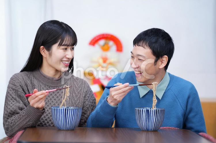 見つめあって話しながら年越しそばを食べる夫婦 夫婦,男性,人物の写真素材