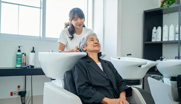 美容室のシャンプー台に座る高齢者女性 美容室のシャンプー台に座る高齢者女性の写真