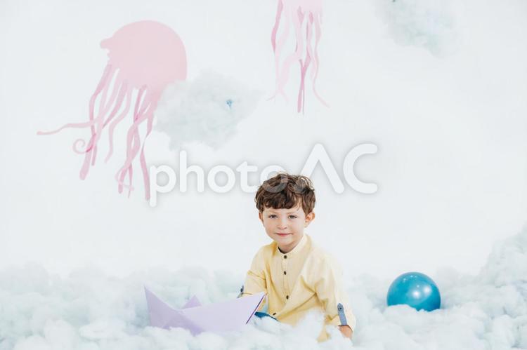 ふわふわの綿の上に座る男の子 男の子,アート,綿の写真素材