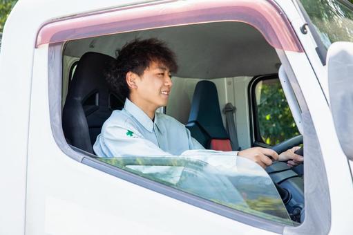 大型トラックを運転する作業服の男性 大型トラックを運転する作業服の男性 トラック,トラック男性,ドライバーの写真素材