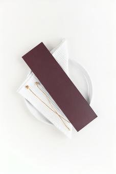 Dried flowers and brown card on a white plate, JPG