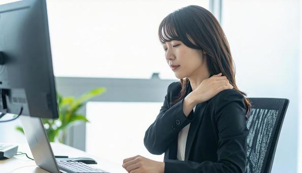 デスクワークで肩こりに悩むビジネスマン デスクワークで肩こりに悩むビジネスマンの写真