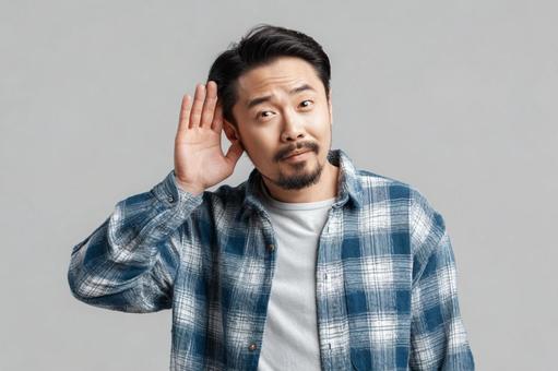 「何?」と聞き耳を立てるアジア人男性 「何?」と聞き耳を立てるアジア人男性の写真