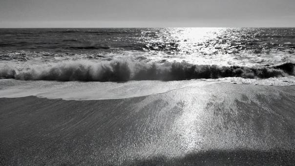 砂浜から見る海と波 砂浜から見る海と波の写真