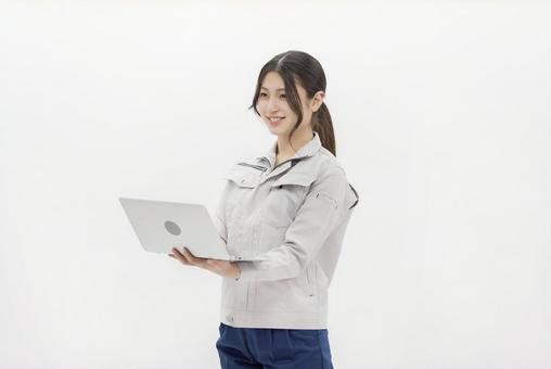 ノートパソコンを使う作業服の女性 ノートパソコンを使う作業服の女性 女性,ビジネスウーマン,作業服の写真素材