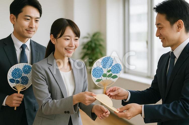 オフィスで団扇を交換するビジネスパーソン ビジネス,団扇,オフィスの写真素材
