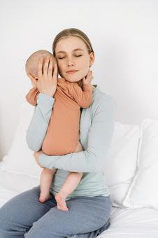 目を瞑り縦抱きで抱っこする女性 目を瞑り縦抱きで抱っこする女性 親子,母子,赤ちゃんの写真素材