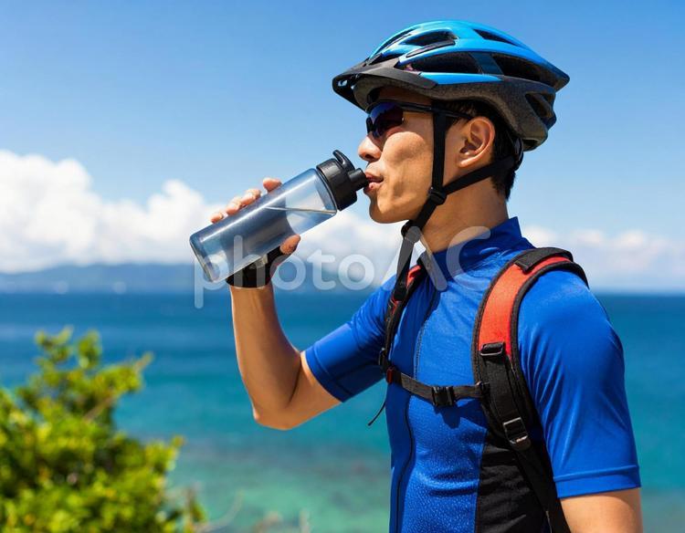サイクリストの夏・休憩と給水（背景に海） サイクリング,サイクリスト,給水の写真素材
