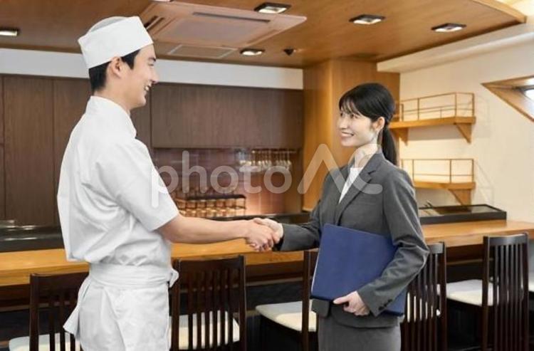 飲食店で握手をするビジネスウーマン 飲食店,握手,成約の写真素材