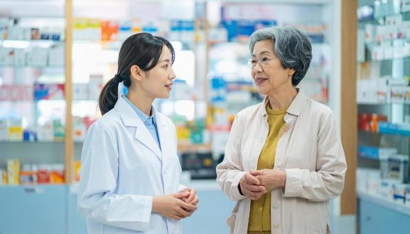 穏やかに話している薬剤師と高齢者 穏やかに話している薬剤師と高齢者の写真