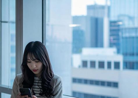 スマホを見る女性の写真