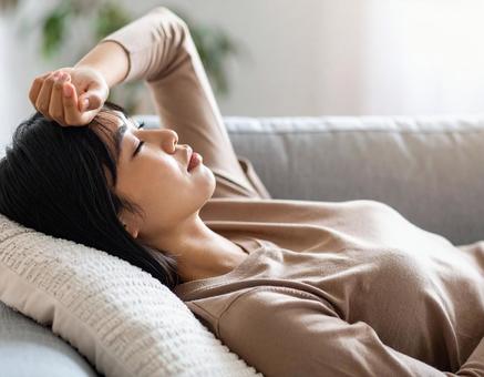 体調不良で寝込む女性 体調不良で寝込む女性の写真