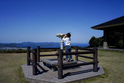 <人物>山の上で双眼鏡を覗く男の子 <人物>山の上で双眼鏡を覗く男の子 子供,双眼鏡,空の写真素材