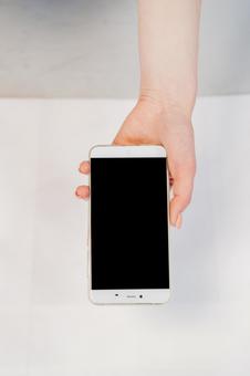 スマートフォンを差し出す手 スマートフォン,手のみ,若者の写真素材