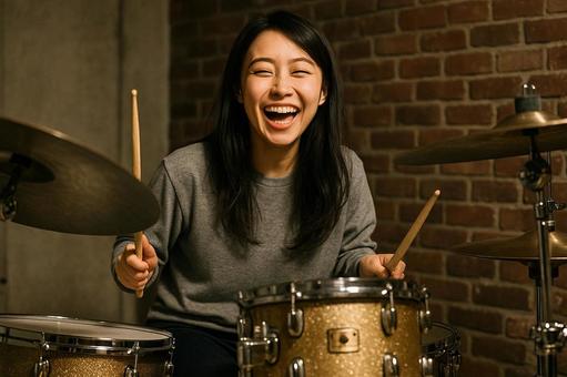 笑顔で楽しそうにドラムを叩く女性ドラマー 笑顔で楽しそうにドラムを叩く女性ドラマーの写真