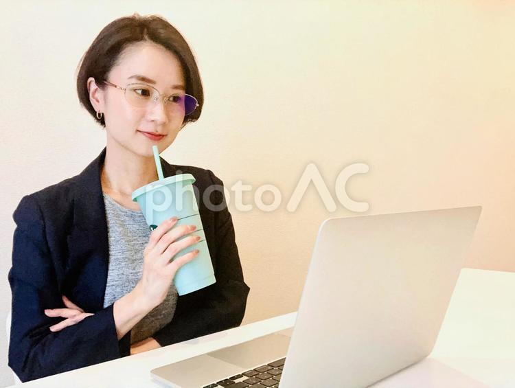 在宅勤務をしながら飲み物を飲む女性 在宅ワーク,女性,リモートワークの写真素材