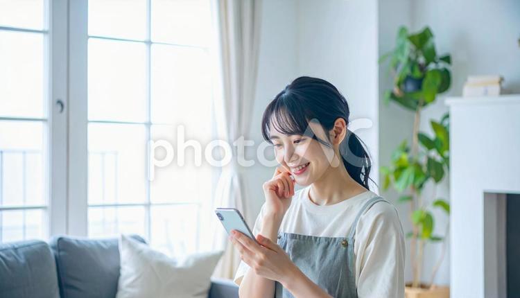 スマホでポイ活する笑顔の女性 スマホ,ポイ活,リビングの写真素材