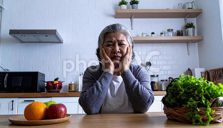 台所のテーブルで頬杖をつく高齢女性 高齢者,女性,人の写真素材