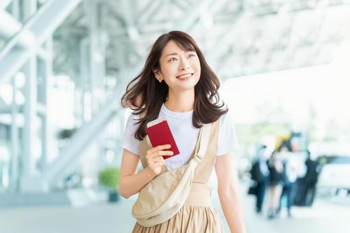 空港でパスポートを持つ旅行中の女性 空港でパスポートを持つ旅行中の女性の写真