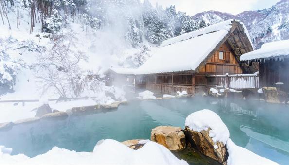 雪の積もる山中の湯気が立ち上る露天風呂 雪の積もる山中の湯気が立ち上る露天風呂の写真