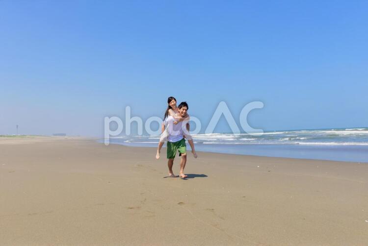 砂浜をおんぶして歩くカップル2 カップル,日本人,夏の写真素材