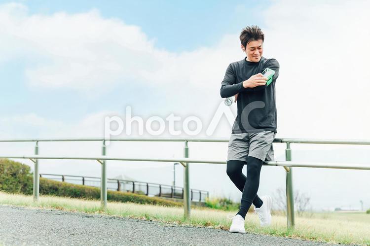 健康管理のためアプリを見るアジア人男性 ランニング,運動,健康管理の写真素材