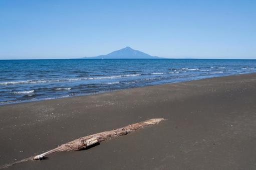砂浜と日本海越しに望む夏の利尻岳 砂浜と日本海越しに望む夏の利尻岳 利尻岳,流木,青い海の写真素材