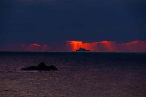 夕陽の海面に指す光芒の中を横切る軍艦 海,海岸,風景の写真素材