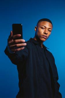 堂々とした表情でスマホを向けるティーン 堂々とした表情でスマホを向けるティーンの写真