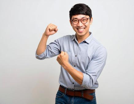 ガッツポーズで喜ぶ若い男性 ガッツポーズで喜ぶ若い男性の写真