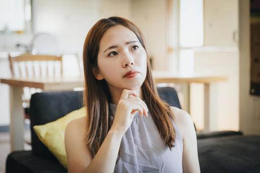 リビングで考え込む女性 リビングで考え込む女性 悩む,悩む女性,浮気の写真素材