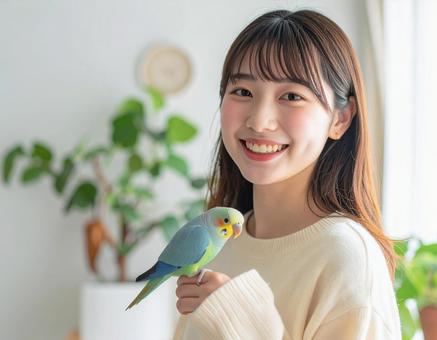 手乗りボタンインコと彼女の写真