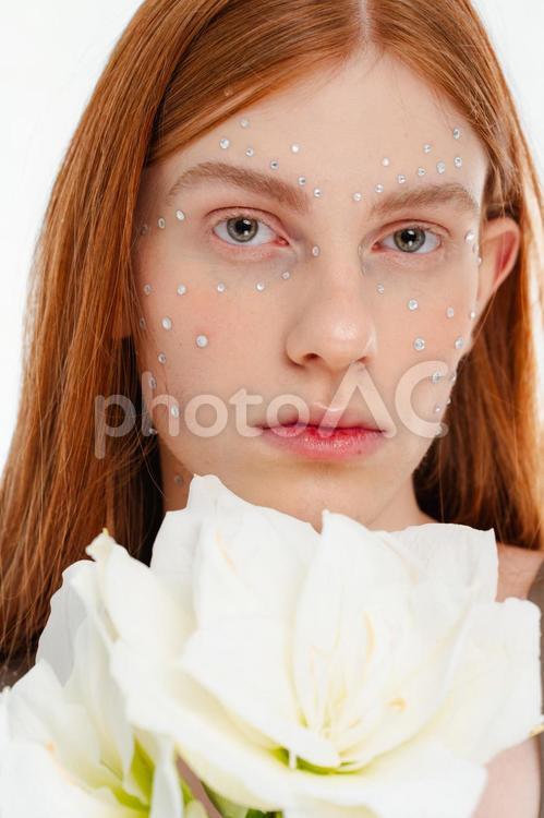 大きな白い花を持つラインストーンメイクの女性 女性,花,アマリリスの写真素材
