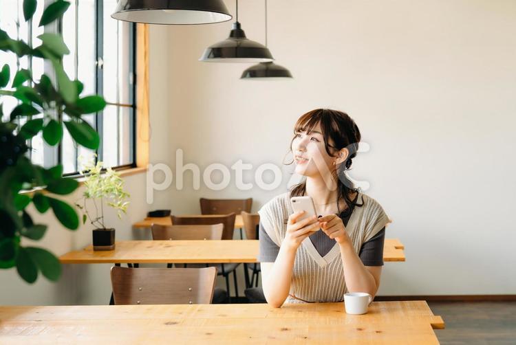 カフェでスマホを使う女性（見る） スマホ,スマートフォン,女性の写真素材